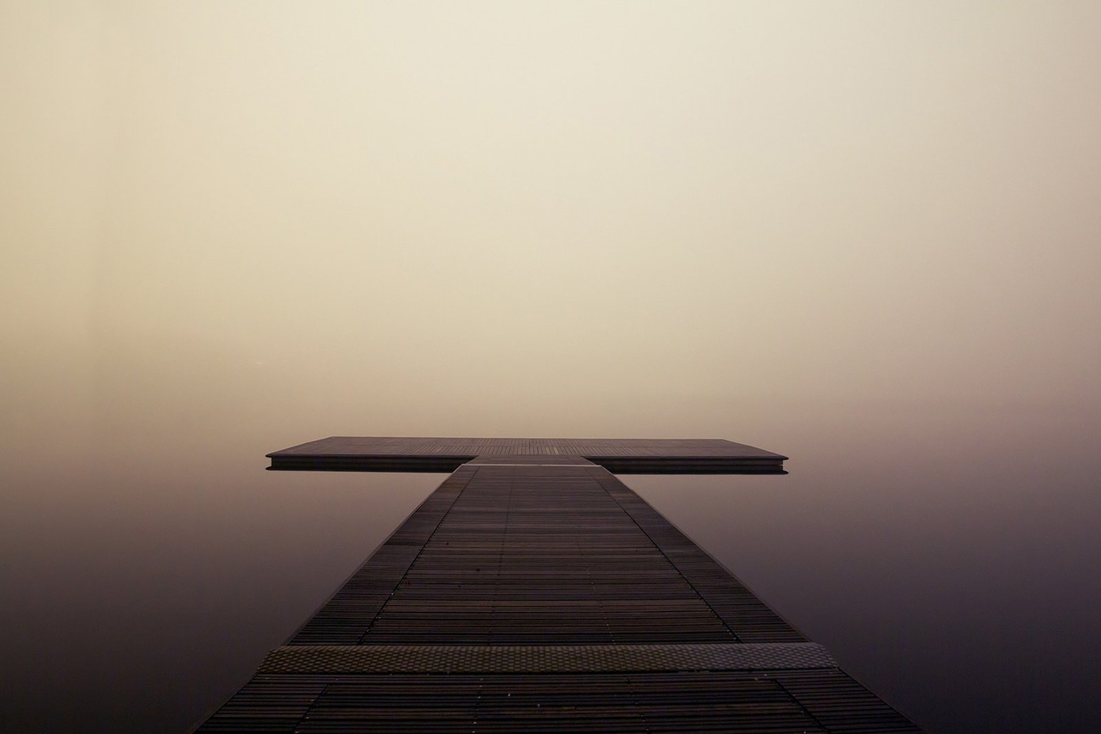 a calm, still pier over misty water, representing a settled and steady state of mind